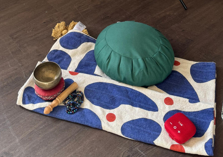 A BabblingZen Chakra Banner with a Zafu set up for meditation